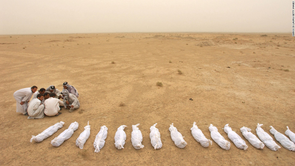 Iraqi men check a list near the remains of bodies excavated from a mass grave on the outskirts of Al Musayyib on May 31, 2003. Locals said they uncovered the remains of hundreds of Shiite Muslims allegedly executed by Saddam Hussein's regime after their uprising following the 1991 Gulf War.