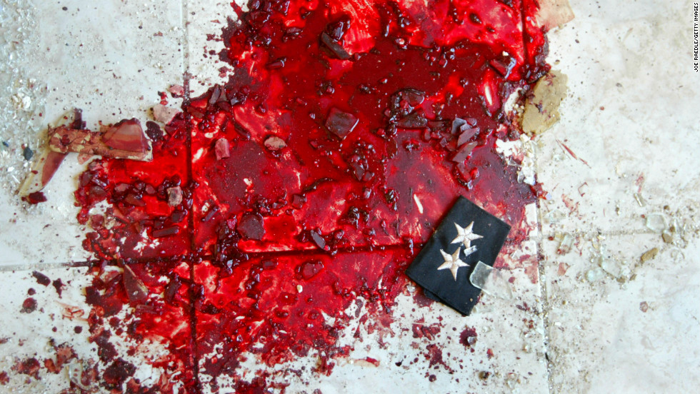 An Iraqi police lieutenant's stars lie in a puddle of blood after a car bombing that targeted a police station in Baquba on November 22, 2003.