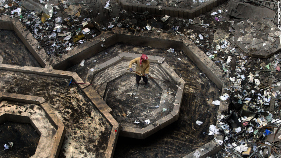 A construction worker removes debris from a destroyed building in Baghdad on December 11, 2003.