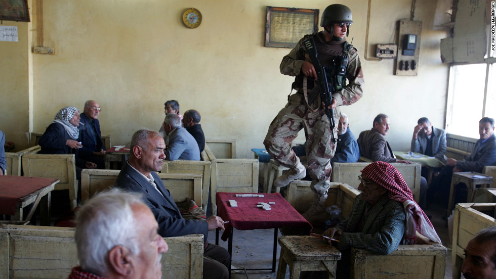 An Iraqi soldier stands watch at a teahouse while on patrol with U.S. soldiers in Baghdad on February 23, 2005.