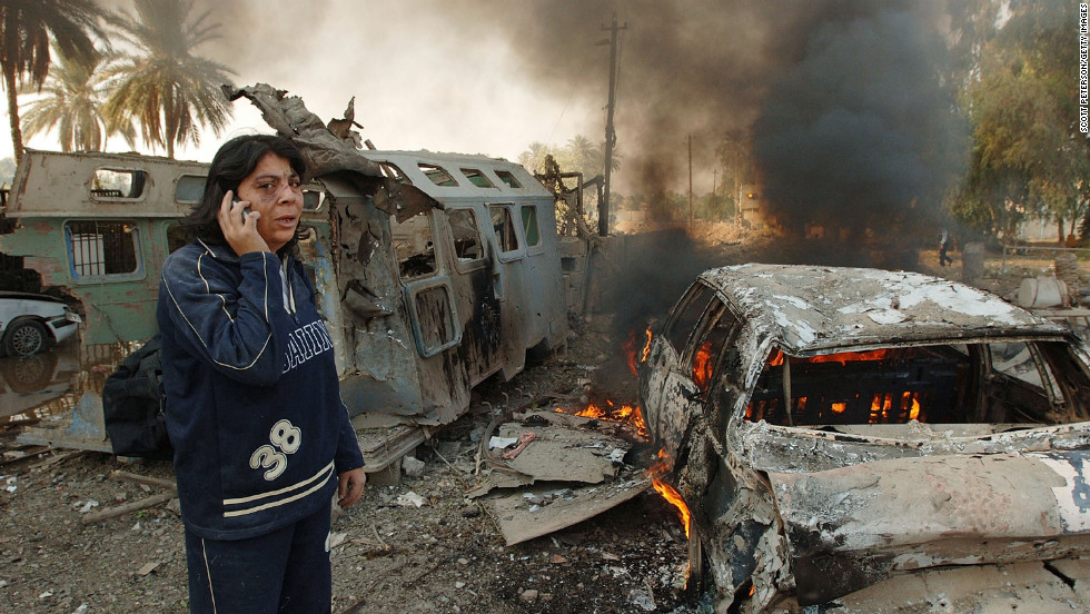 A resident makes a phone call in the aftermath of a double suicide car bombing that struck civilians living near the blast walls that protect the Hamra Hotel in Baghdad on November 18, 2005.