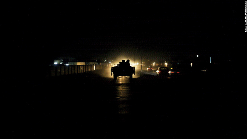 A British armored vehicle is illuminated by traffic during a patrol of Basra on July 27, 2006.