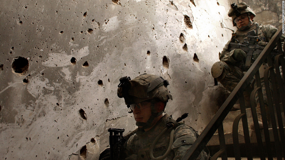 U.S. soldiers sit in a home damaged by fighting in Baghdad on March 11, 2008, near the five-year anniversary of the war.