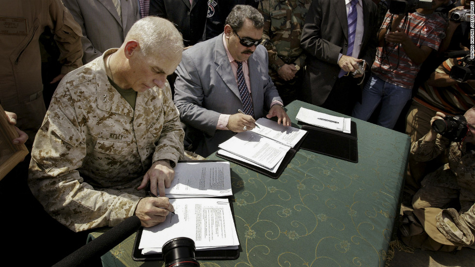 Maj. Gen. John Kelly, left, and Anbar province Gov. Maamoun Sami Rashid al-Alwani sign papers during a handover ceremony in Ramadi on September 1, 2008. The U.S. military turned over security control of Iraq's biggest province, once a stronghold of the Sunni insurgency.