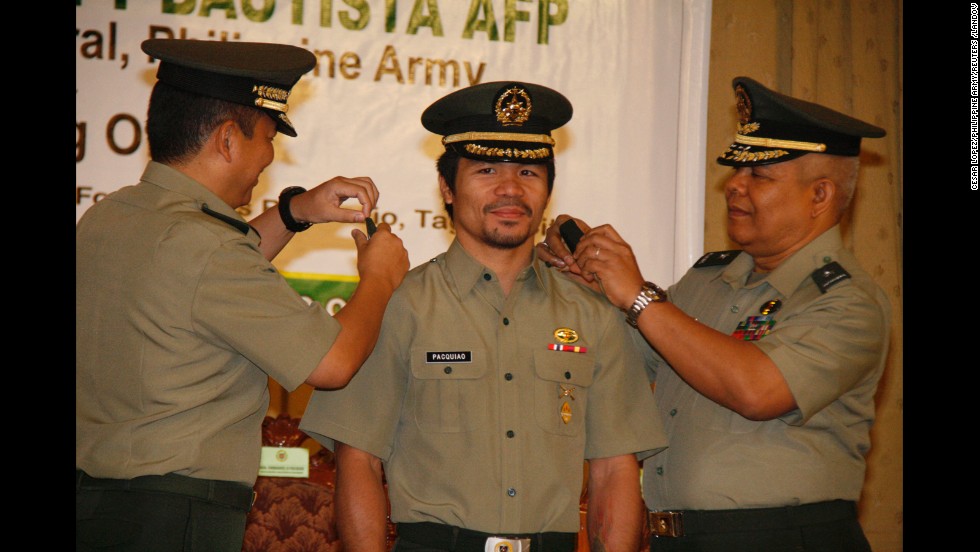 Pacquiao is conferred the rank of lieutenant colonel by Maj. Gen. Emmanuel Bautista, left, and Brig. Gen. Alex Albano, right, in Manila, on December 5, 2011.