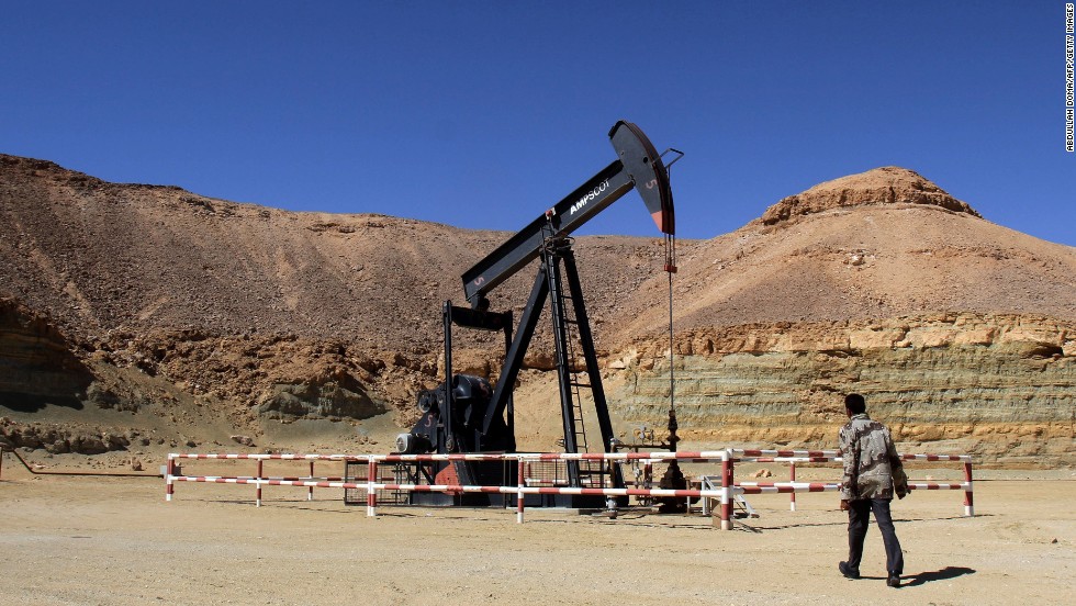 A security worker walks by an oil drill on March 23 at the al-Ghani oil field, owned by the Harouge Oil Operations company, near the city of Waddan.