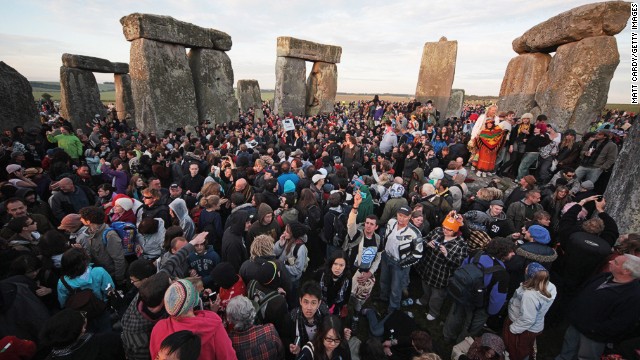 AMESBURY, ENGLAND - JUNE 21: Revellers watch as the midsummer sun rises just after dawn over the megalithic monument of Stonehenge on June 21, 2010 on Salisbury Plain, England. Thousands of revellers gathered at the 5,000 year old stone circle to see the sunrise on the Summer Solstice, which is the longest day of the year in the Northern Hemisphere.