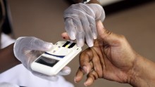 A mans finger is pricked to test his cholesterol at the City of Newark's free homeless health fair at the Department of Child and Family Well-Being on August 13, 2009 in Newark, New Jersey. The Department of Child and Family Well-Being in partnership with other health organizations gave free medical examinations to the homeless including screening for high blood pressure, cancer, and diabetes. (Photo by Rick Gershon/Getty Images)