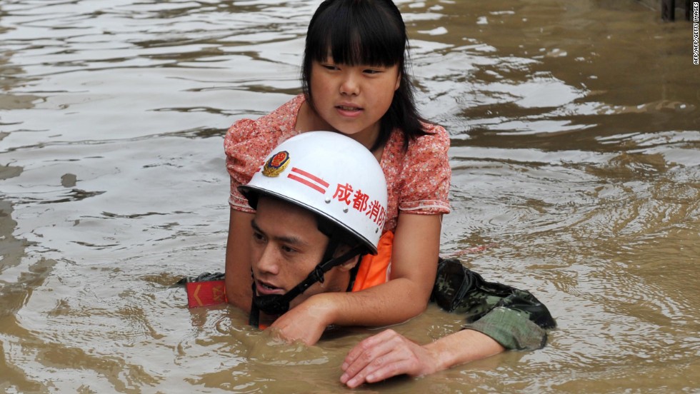 A rescuer helps a woman escape the floodwaters of the Tuo on July 11.