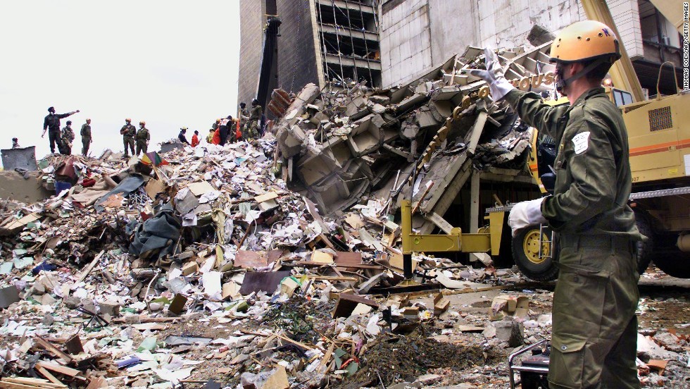 Rescue workers stand on the remains of a building in front of the <a href="http://www.cnn.com/WORLD/africa/9808/08/africa.explosions.01/">U.S. Embassy in Nairobi, Kenya,</a> on August 10, 1998, four days after a deadly attack. Twelve Americans were among more than 200 people killed in nearly simultaneous bombings at U.S. embassies in Nairobi and Dar es Salaam, Tanzania.