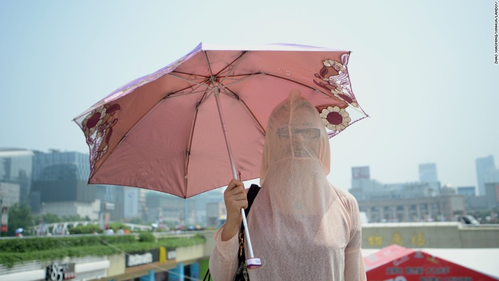 A woman wears her clothes backward against the scorching sun in Jinan, China, on August 4.