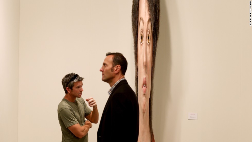 Lance Vickery, left, looks at a work by Evan Penny titled "female stretch variation # 2" on December 5.