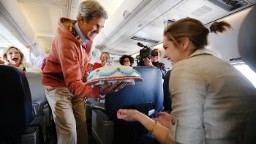 During a flight from Kabul, Afghanistan, to Paris in March 2013, Kerry presents a birthday cake to traveling CBS correspondent Margaret Brennan.