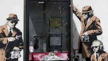 A boy walks past a piece of new graffiti street art on April 14 believed to be by the underground artist Banksy which appeared on the side of a house in Gloucestershire, England.