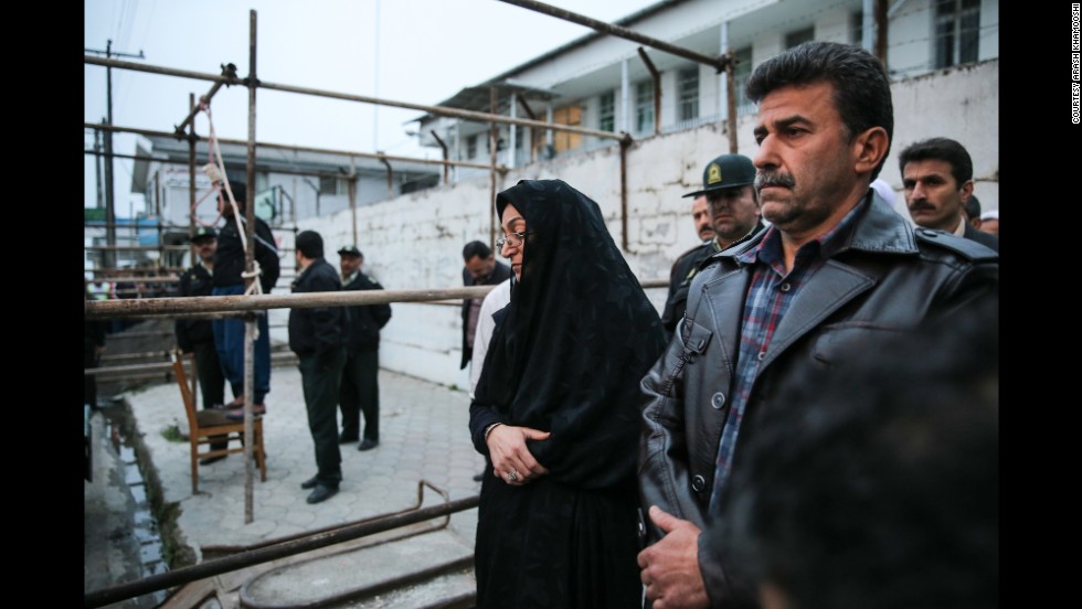 Maryam and Abdulghani Hosseinzadeh, the victim&#39;s parents, stand next to the execution platform as Balal is prepared to be hanged.