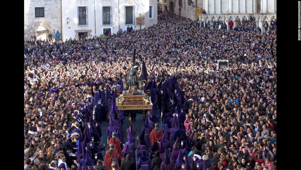 Penitents, surrounded by several thousand people in Cuenca, Spain, carry a statue of Our Father Nazarene during the Good Friday procession "Way of Calvary."