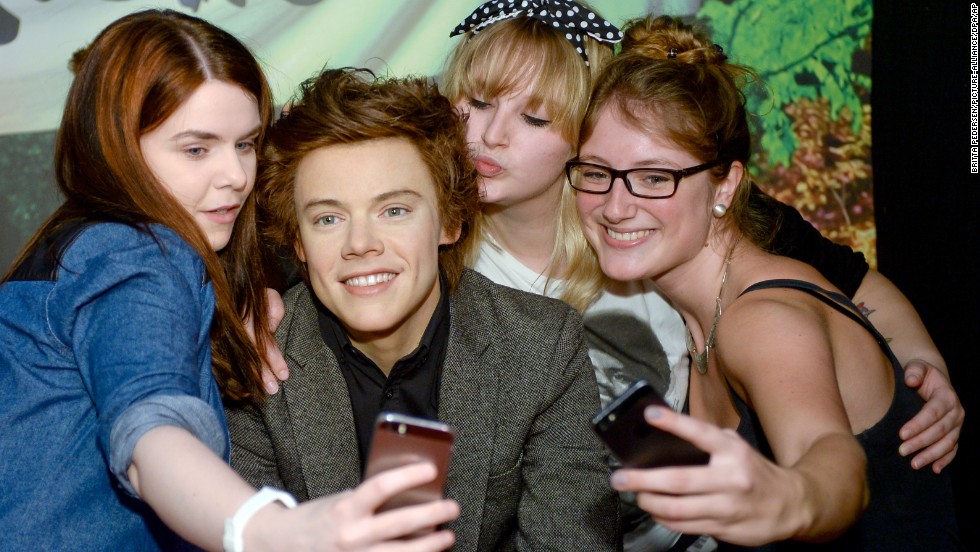 Fans of the boy band One Direction take a selfie with a Harry Styles wax figure Wednesday, June 25, at Madame Tussauds in Berlin.