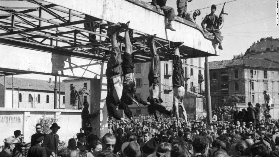 The bodies of Benito Mussolini, left, and his mistress, Clara Petacci, second from left, hang from the roof of a gasoline station after they were shot by anti-Fascist forces while attempting to escape to Switzerland on April 28, 1945.
