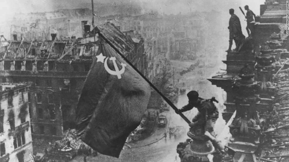 Russian soldiers wave their flag, made from tablecloths, over the ruins of the Reichstag in Berlin on April 30, 1945. That day, as the Soviets were within blocks of his bunker at the Reich Chancellery, Adolf Hitler committed suicide. 