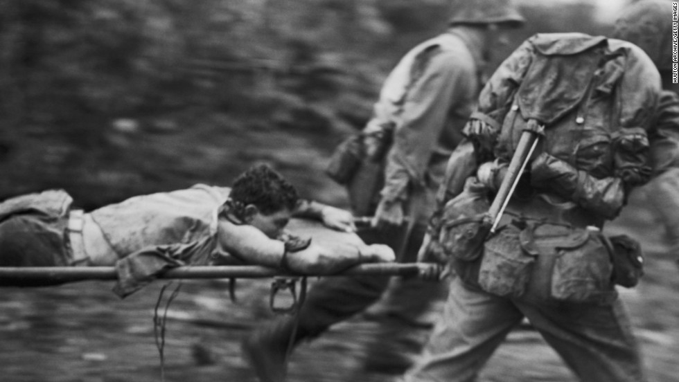 Soldiers rush an injured U.S. Marine from a battlefield during the Battle of Okinawa in June 1945. The battle, the bloodiest of the war in the Pacific, raged for nearly three months and heightened U.S. concerns for the enormous casualties that could be anticipated in the planned invasion of Japan&#39;s main islands.