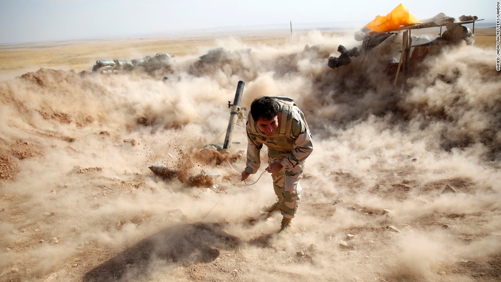 A Kurdish Peshmerga fighter launches mortar shells toward ISIS militants in Zumar, Iraq, on Monday, September 15.