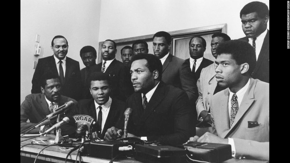 As a conscientious objector to the Vietnam War, Ali refused induction into the U.S. Army in April 1967. Here, top athletes from various sports gather to support Ali as he gives his reasons for rejecting the draft. Seated in the front row, from left to right, are Bill Russell, Ali, Jim Brown and Kareem Abdul-Jabbar.