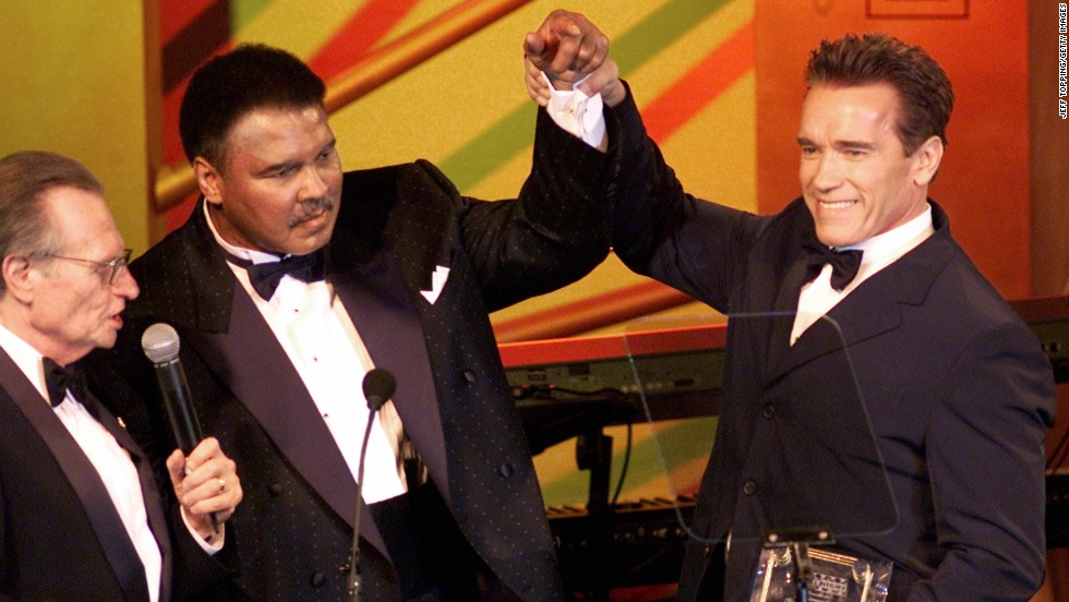 Actor Arnold Schwarzenegger raises Ali&#39;s hand during the Celebrity Fight Night charity event in Phoenix in March 2002. Schwarzenegger was presented with the Muhammad Ali Humanitarian Award for his work with the Muhammad Ali Parkinson Research Foundation, the Inner-City Games Foundation and the Special Olympics. The award was presented by former CNN host Larry King, left.
