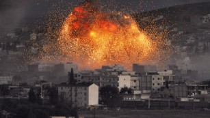 An explosion rocks Kobani, Syria, during a reported suicide car bomb attack by ISIS militants on Monday, October 20.