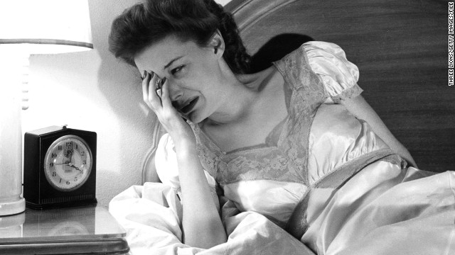 circa 1955: A woman crying as she looks at her bedside clock. (Photo by Three Lions/Getty Images