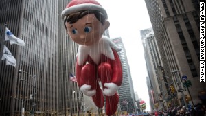 The Elf on a Shelf ballon is led down the parade route. 