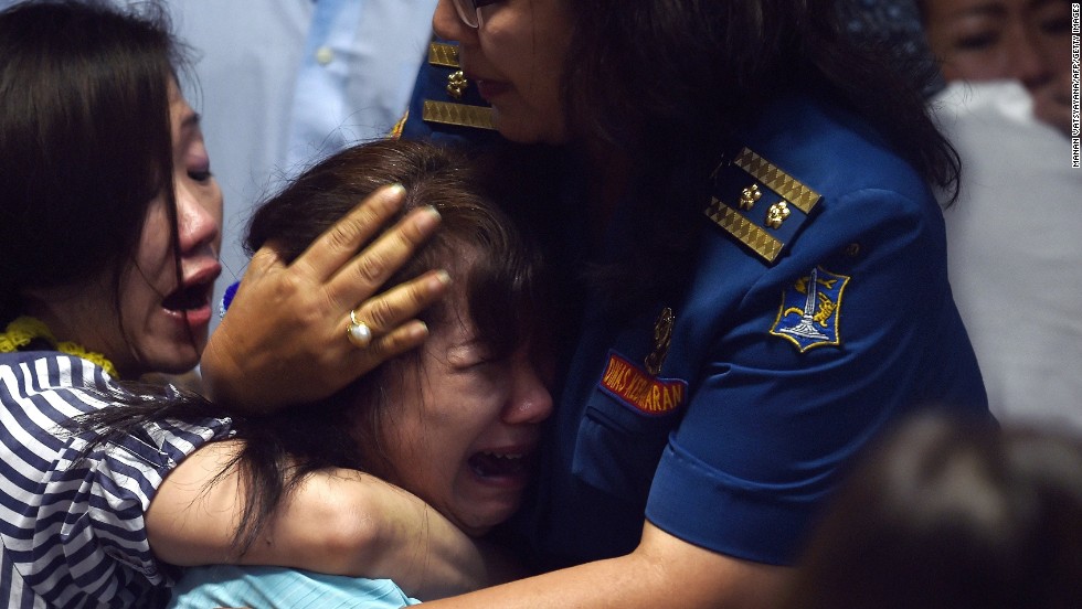 Family members of missing passengers react at an airport in Surabaya after watching news reports on December 30.