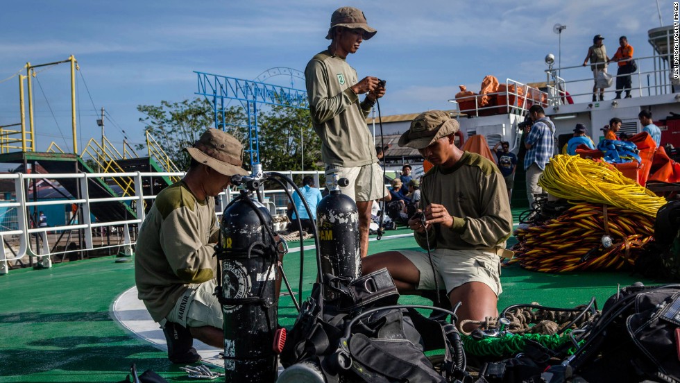 Marine divers prepare their gear on the deck of a ship before searching for passengers and debris January 1 at Kumai port in Pangkalan Bun.