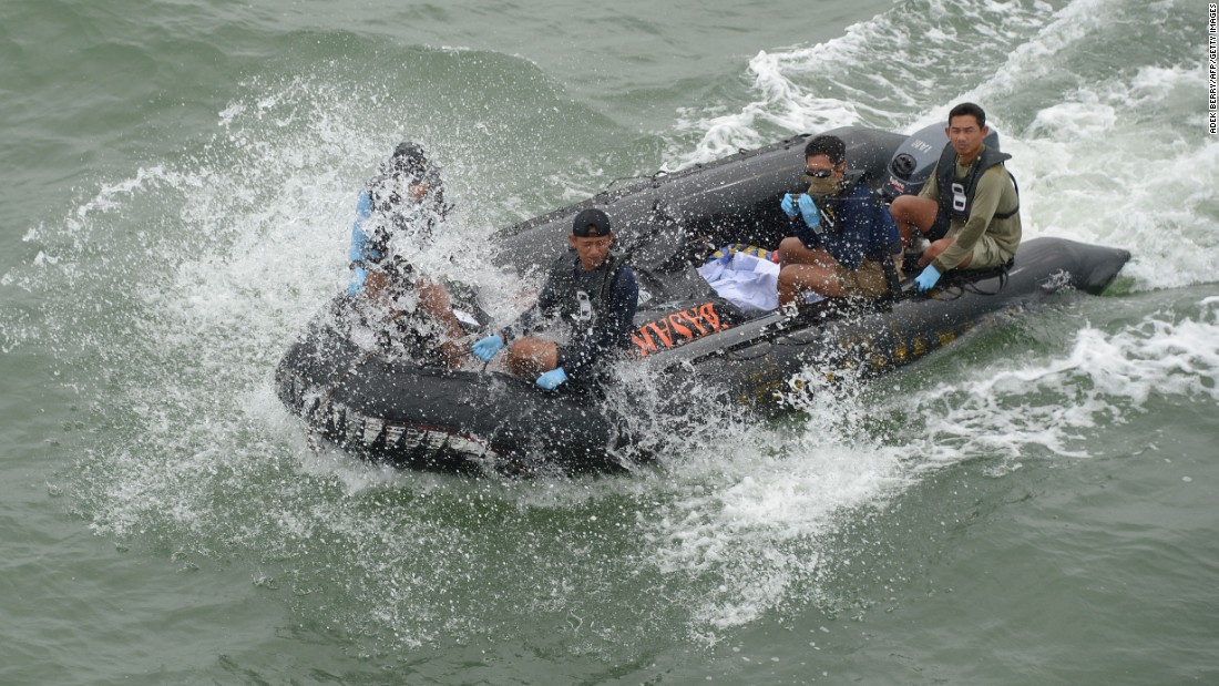 Members of the Indonesian navy return to the vessel with remains recovered from the crash area.