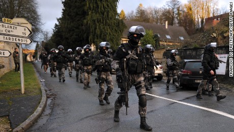 French police special forces walk down a street in Corcy, France, on January 8.