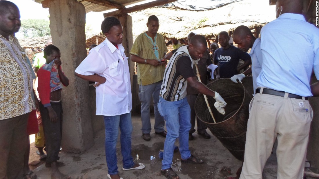 Mozambique government officials gather samples from a drum that was allegedly used to make local beer.