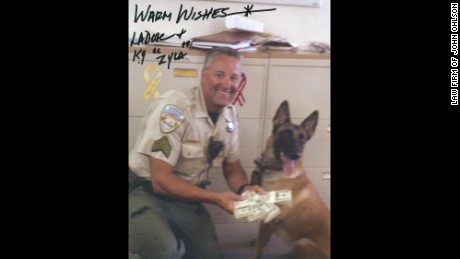 Sheriff Lee Dove autographed photos of himself with a bundle of money.