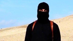 A video released by ISIS on social media Tuesday, Jan. 20, 2015, purportedly shows a masked man standing over two kneeling men in orange jumpsuits. The terror groups threatened to kill the two Japanese hostages unless Tokyo pays $200 million.