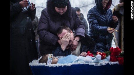 Vladimir Bovrichev cries next to the body of his 4-year-old son, Artiam, during Artiam's funeral on the outskirts of Donetsk on Tuesday, January 20. The boy was killed during a Ukrainian artillery strike.