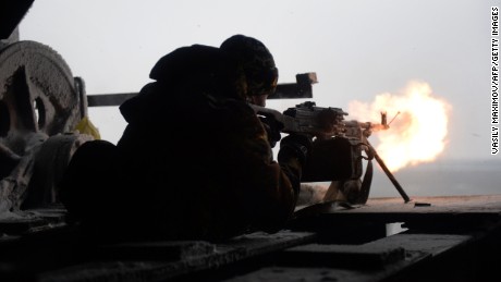 A Ukrainian volunteer fighter fires a machine gun at pro-Russian rebels near the village of Pisky, Ukraine, on Saturday, January 3.
