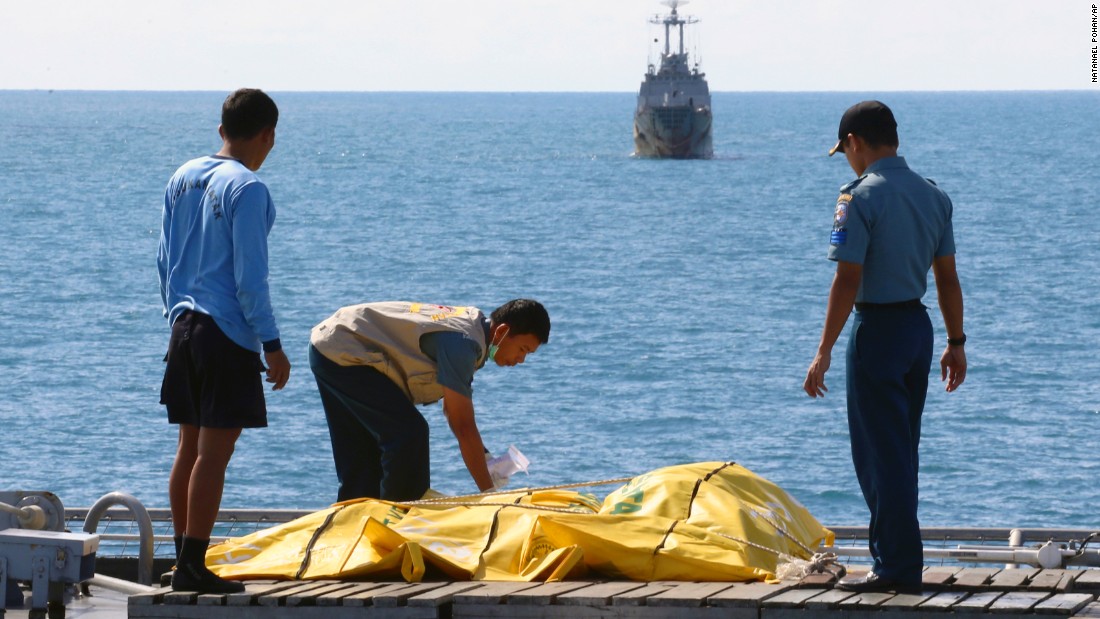 Crew members inspect bags containing bodies believed to be AirAsia flight victims on the deck of an Indonesian navy ship in the Java Sea on Friday, January 23.