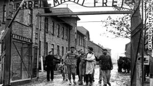 A doctor, center, with  the 322nd Rifle Division of the Red Army, walks with a group of survivors at the entrance to the newly liberated Auschwitz I concentration camp in January 1945. The Red Army liberated the camp on January 27, 1945. Above the gate is the motto &quot;Arbeit macht frei,&quot; which translates to &quot;Work sets you free.&quot; 