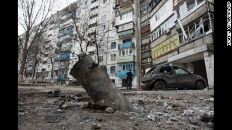 A piece of an exploded missile sits lodged in the ground outside an apartment building in the Vostochniy district of Mariupol on Sunday, January 25.