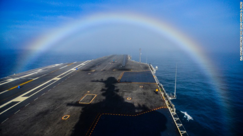 A rainbow forms over the bow of the Nimitz-class aircraft carrier USS John C. Stennis as the ship steams in the Pacific Ocean on February 3, 2015. 