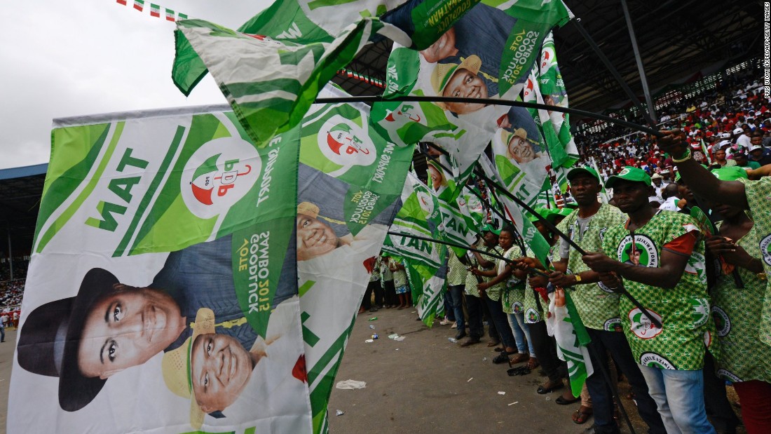 Supporters at a PDP rally in the Niger Delta wave flags bearing President Jonathan's portrait on January 28.<br />