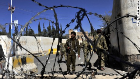 Houthi fighters guard the gate of the presidential palace where a bomb went off and wounded three people in Sanaa on Saturday, February 7.