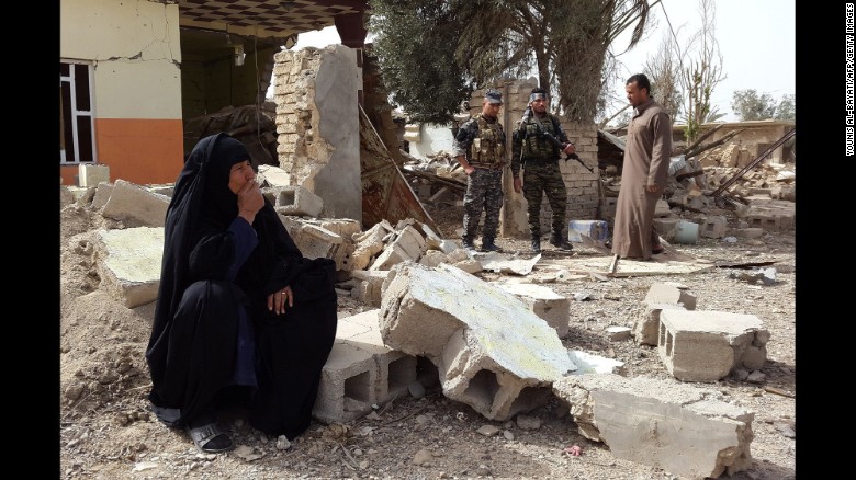 A woman looks at her destroyed home after returning to the village of Al-Mansuriya, Iraq, on Saturday, February 14.