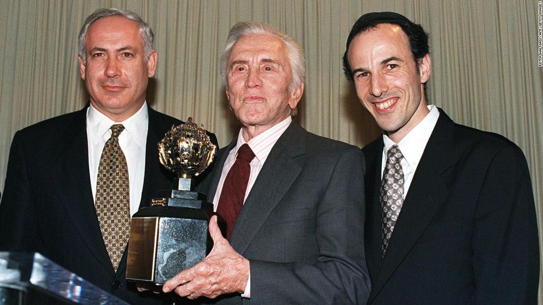 Actor Kirk Douglas holds the King David Award, presented to him by the Jerusalem Fund Aish Ha Torah during a dinner in Beverly Hills, California, on November 17, 1997. Douglas was honored for his inspirational commitment to Israel and the Jewish people and in recognition of his new book &quot;Climbing the Mountain.&quot; Netanyahu is on the left. To the right is Rabbi Nachum Braverma, director of the Jerusalem Fund Aish Ha Torah.