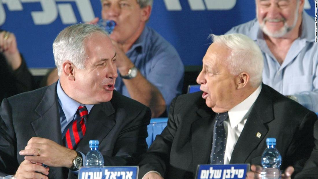 Netanyahu, as Israel's foreign minister, laughs with Israeli Prime Minister Ariel Sharon at the start of a Likud convention in Tel Aviv on November 12, 2002.