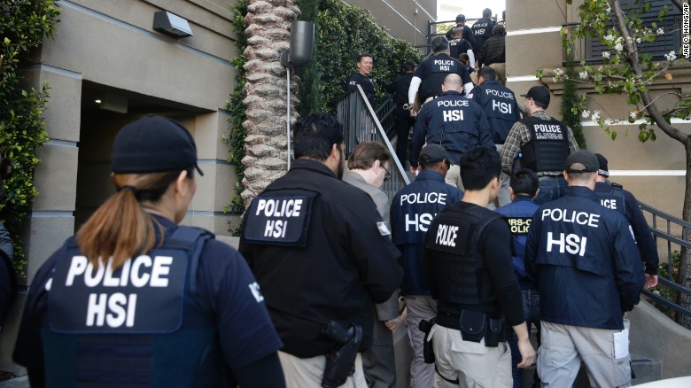 Federal agents enter an upscale apartment complex on Tuesday, March 3, in Irvine, California. More than three dozen &quot;maternity hotels&quot; were raided in Southern California, where foreign women give birth, allegedly for the sole purpose of having a U.S.-citizen baby, authorities said.