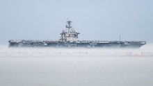 The aircraft carrier USS Theodore Roosevelt departs Naval Station Norfolk, Virginia, on Wednesday, March 11, for a scheduled deployment. The Nimitz-class carrier's departure was delayed for two days after marine growth clogged sea water intakes. Divers went into the 36-degree water to clean out the intakes and allow the ship to get under way. The cold water created a fog that made it seem the ship was in a cloud.